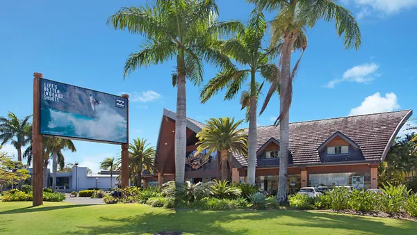 A Billabong store as seen from the outside. Palm trees stand on the grounds.