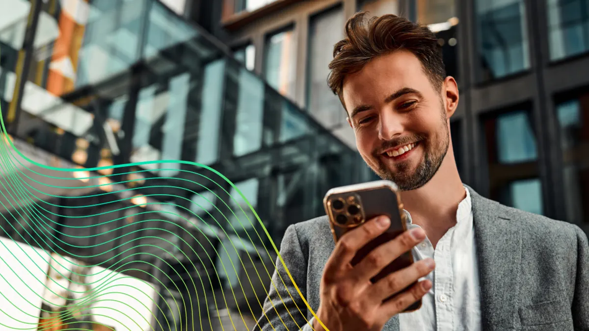 Professional looking down at smartphone and smiling.