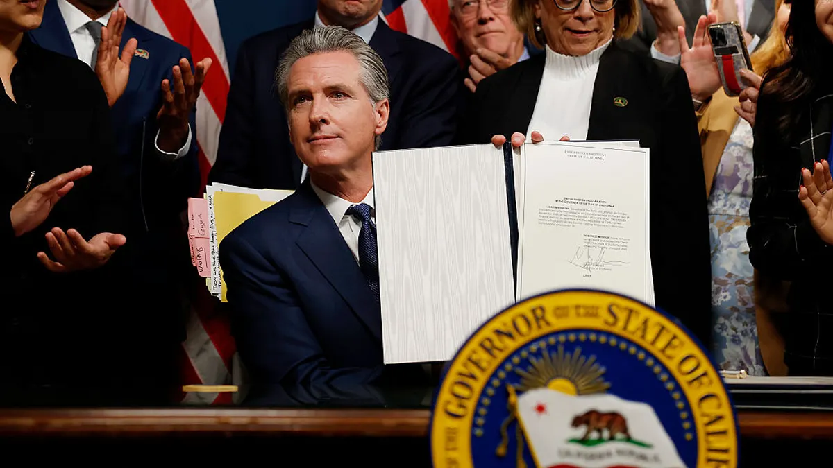 California Gov. Gavin Newsom seen holding a signed bill.