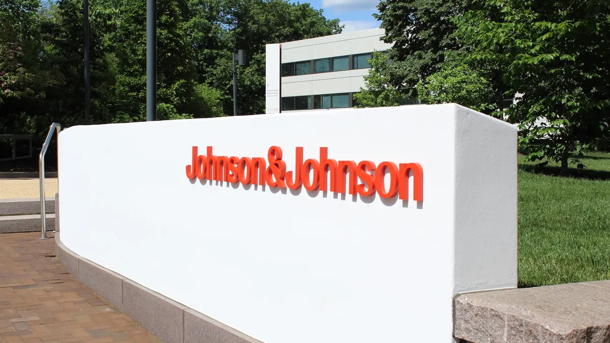 A wall bearing the Johnson & Johnson logo is seen outside of an office building.