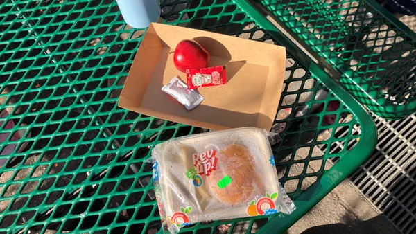 A cheeseburger served in a compostable food container at San Francisco's Jefferson Elementary School, on Dec. 15, 2025. The container is wrapped in plastic film to ensure food safety and to avoid spillage during transport.