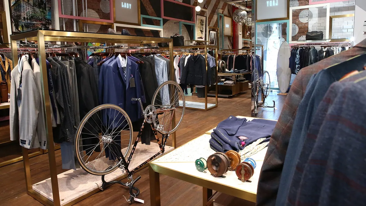 The interior of a Ted Baker store in New York City shows wooden floors and clothing on racks.