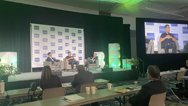 Two GFL executives and one Stifel analyst sit on a stage at WasteExpo 2024