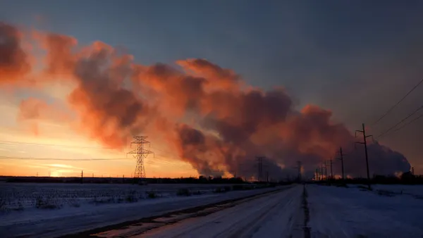 Steam rises from a power plant at sunset.