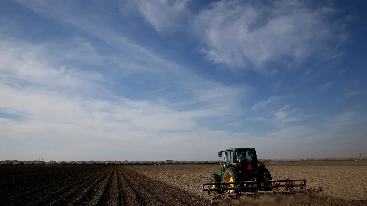 A tractor plows a field