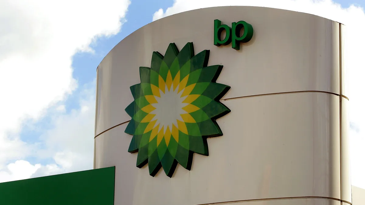 A sign with a design and the letters "bp" against a blue sky