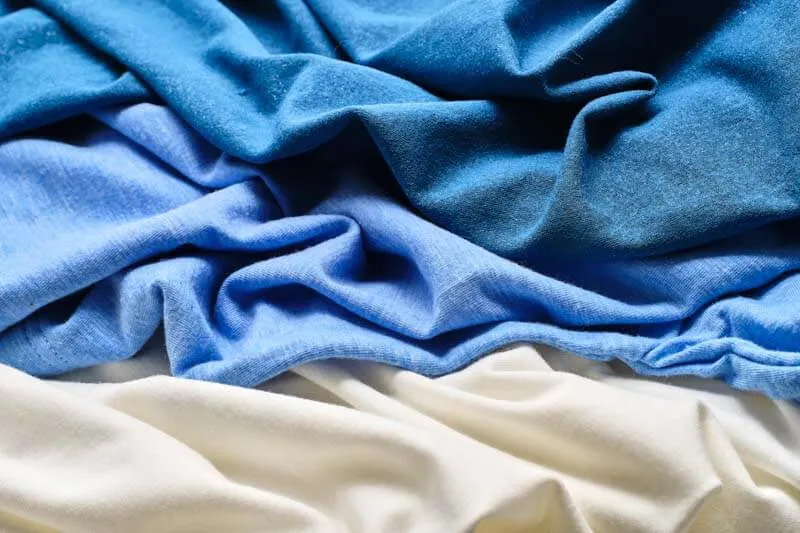 Image of blue fabric and white fabric folded against each other.