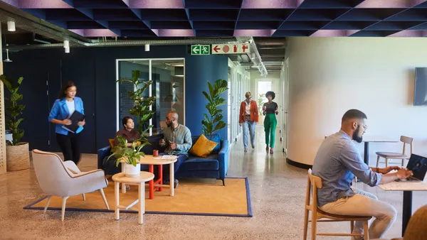 A group of worker in a lounge area of a modern office space.