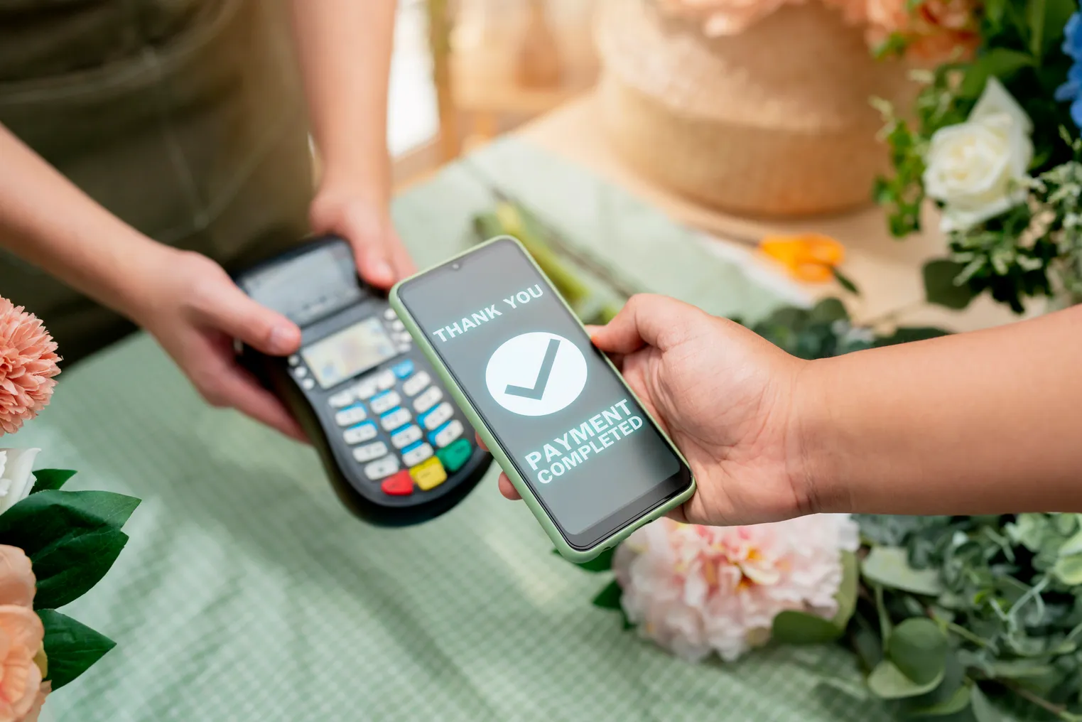 Close up of easy payment by credit card or smartphone application Greenhouse workers selling pottered flowers.