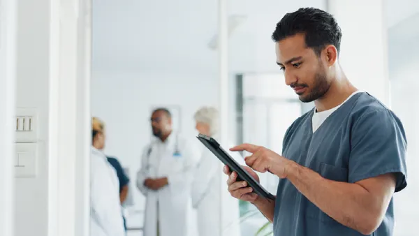 A male nurse using a digital tablet