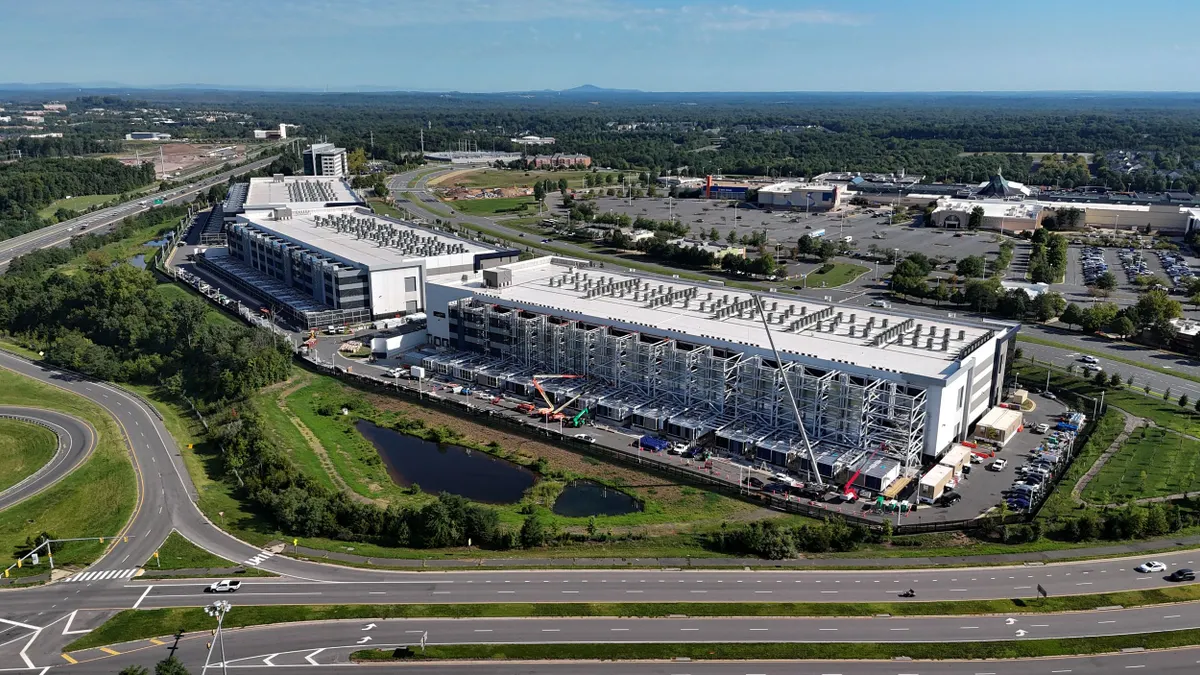 An aerial view of the construction of a large data center under construction next to a highway