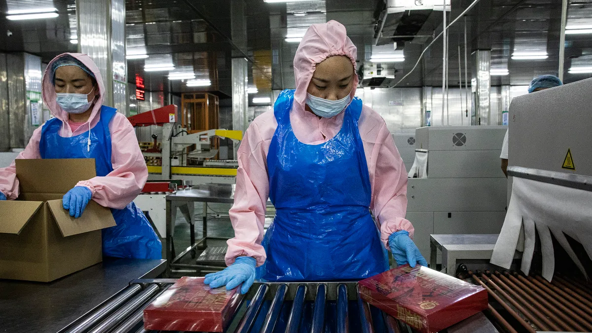 Employees prepare crayfish products along an assembly line at a processing plant on June 30, 2022 in Honghu, Hubei, China.