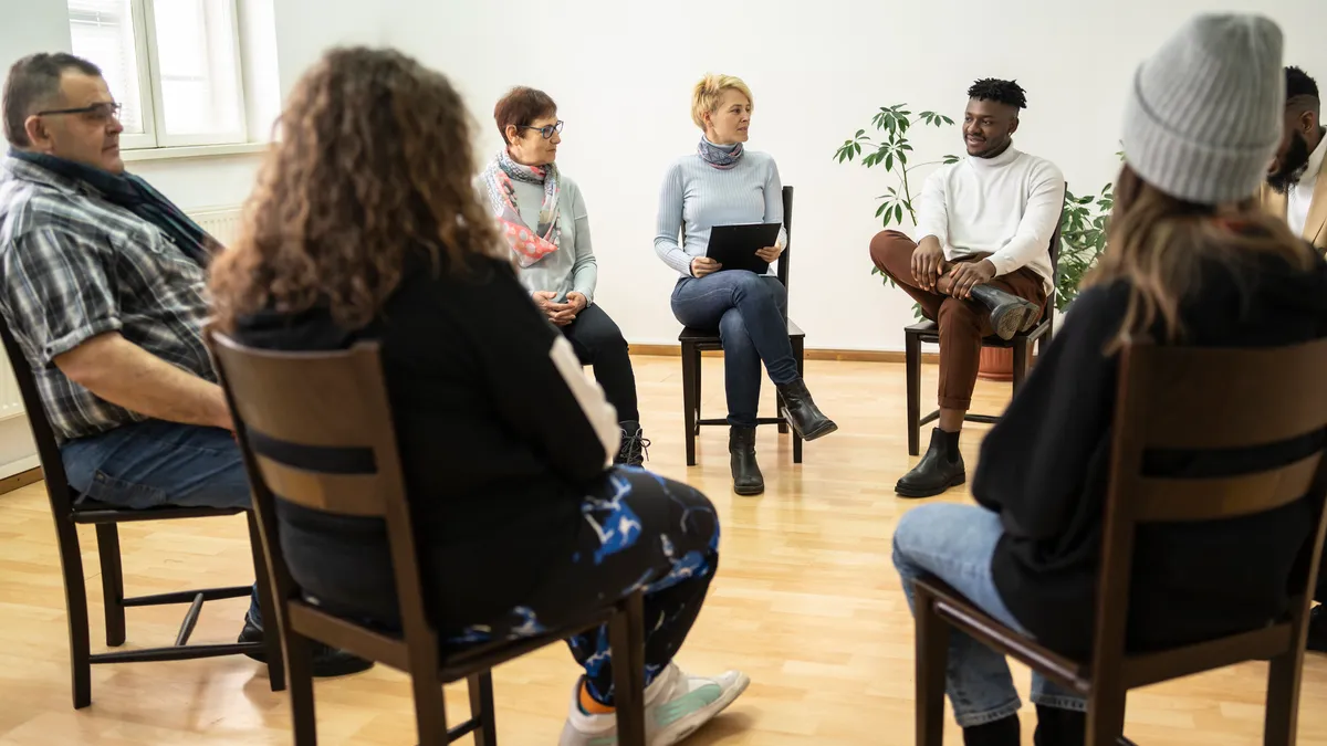 Group therapy support meeting talking about their mental health in a modern mental health facility