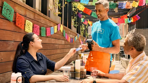 Restaurant server collecting payment from guests at table