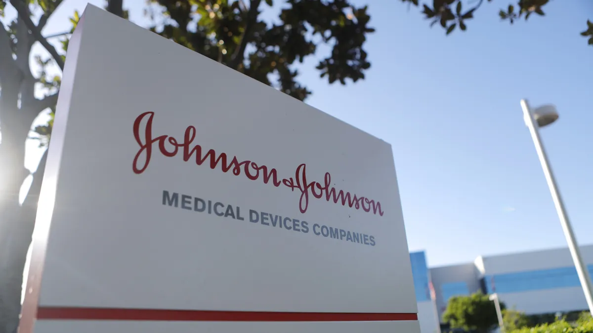 A sign with company logo in red on a white background at the entrance to Johnson & JOhnson medical device unit