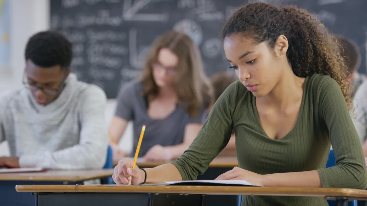 A high school student takes a standardized test during class.