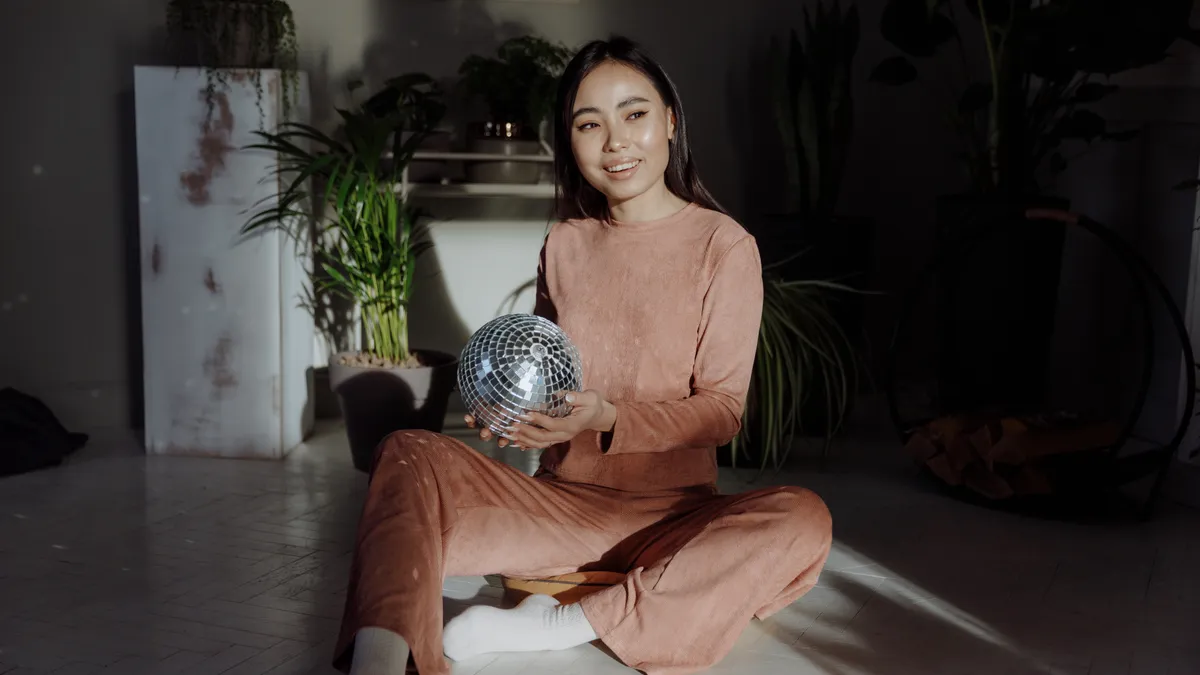 A person sits with a disco ball