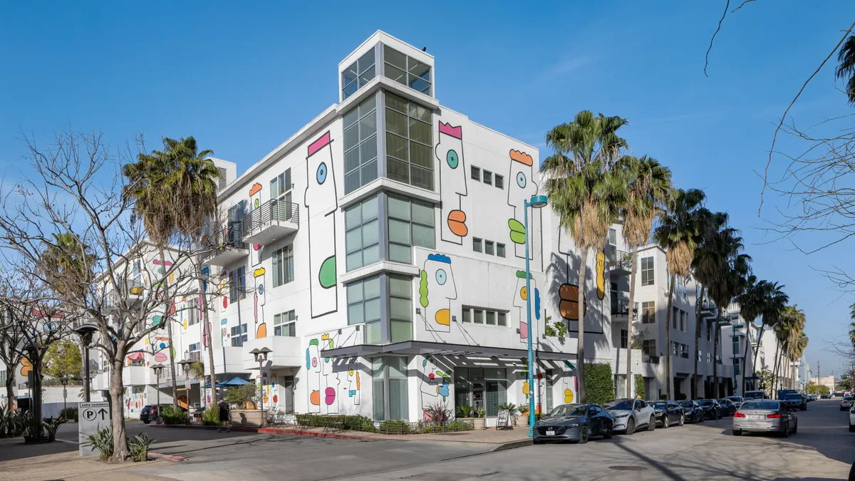 white apartment building with art on the walls