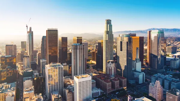 An aerial view of buildings and skyscrapers in downtown Los Angeles at sunset
