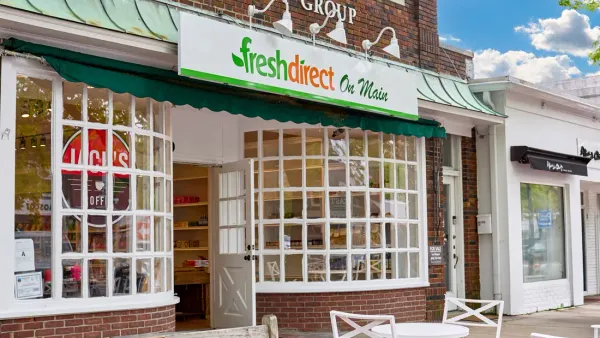 A building with a brick front, windows in white frames and a sign that says "FreshDirect on Main."