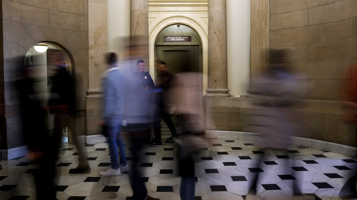 Blurred people are seen in front of the office of U.S. Speaker Mike Johnson