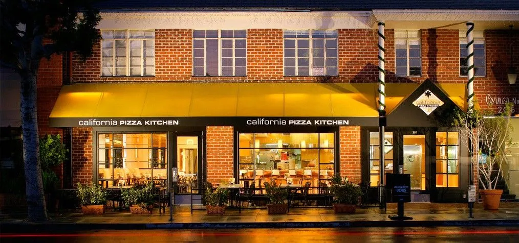 An image of a brick building with yellow signage that says &quot;California Pizza Kitchen.&quot;