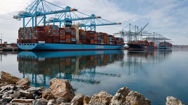 Shipping cranes above cargo vessels at an ocean port.