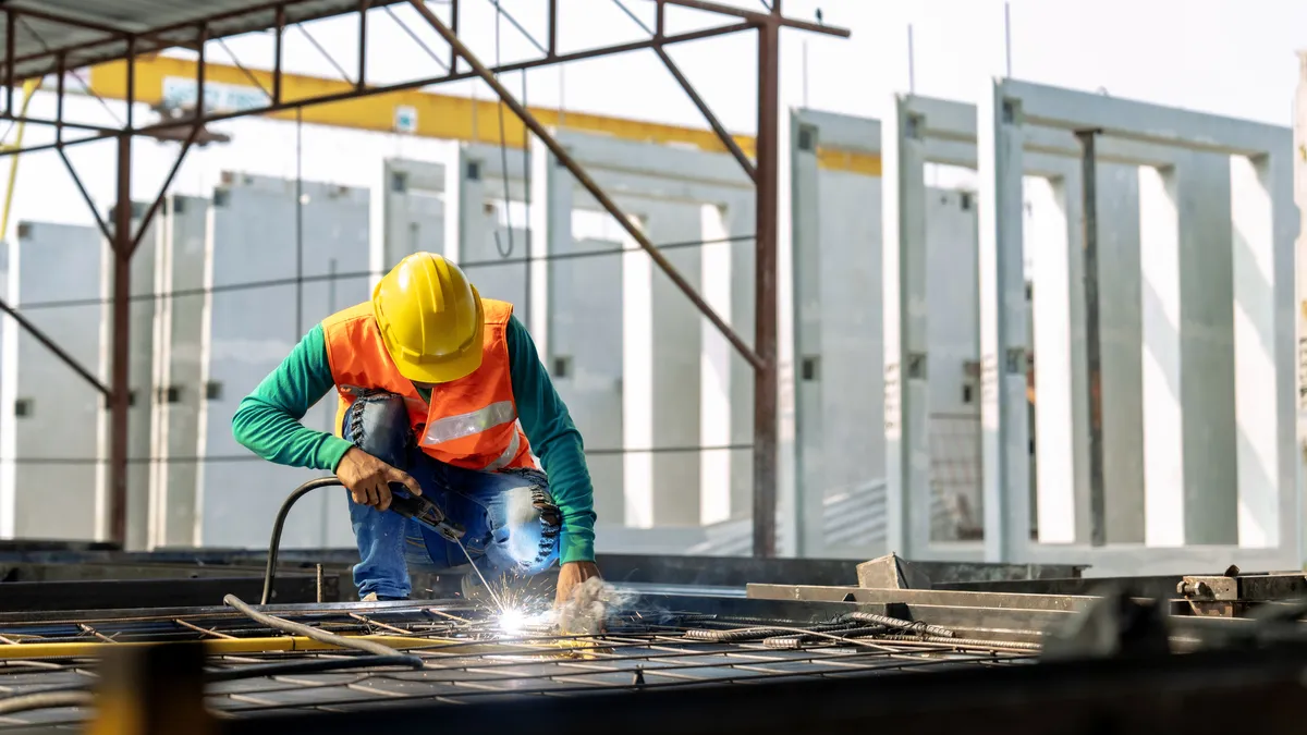 A construction worker welds rebar