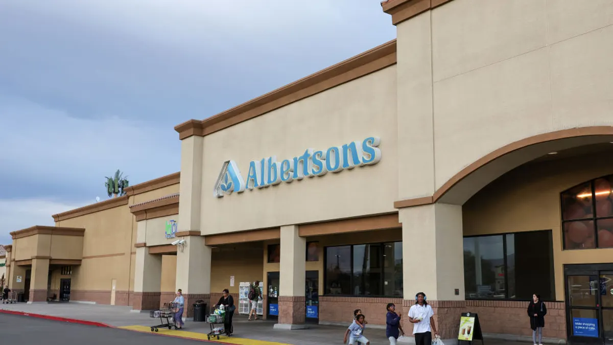 Shoppers walk outside an Albertsons grocery store.