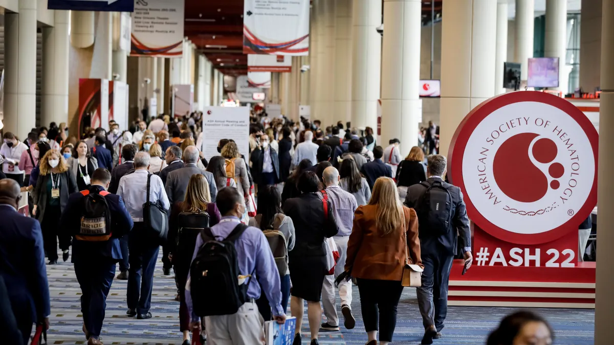 Attendees of the American Society of Hematology's annual meeting walk through a conference hall in New Orleans in December 2022.