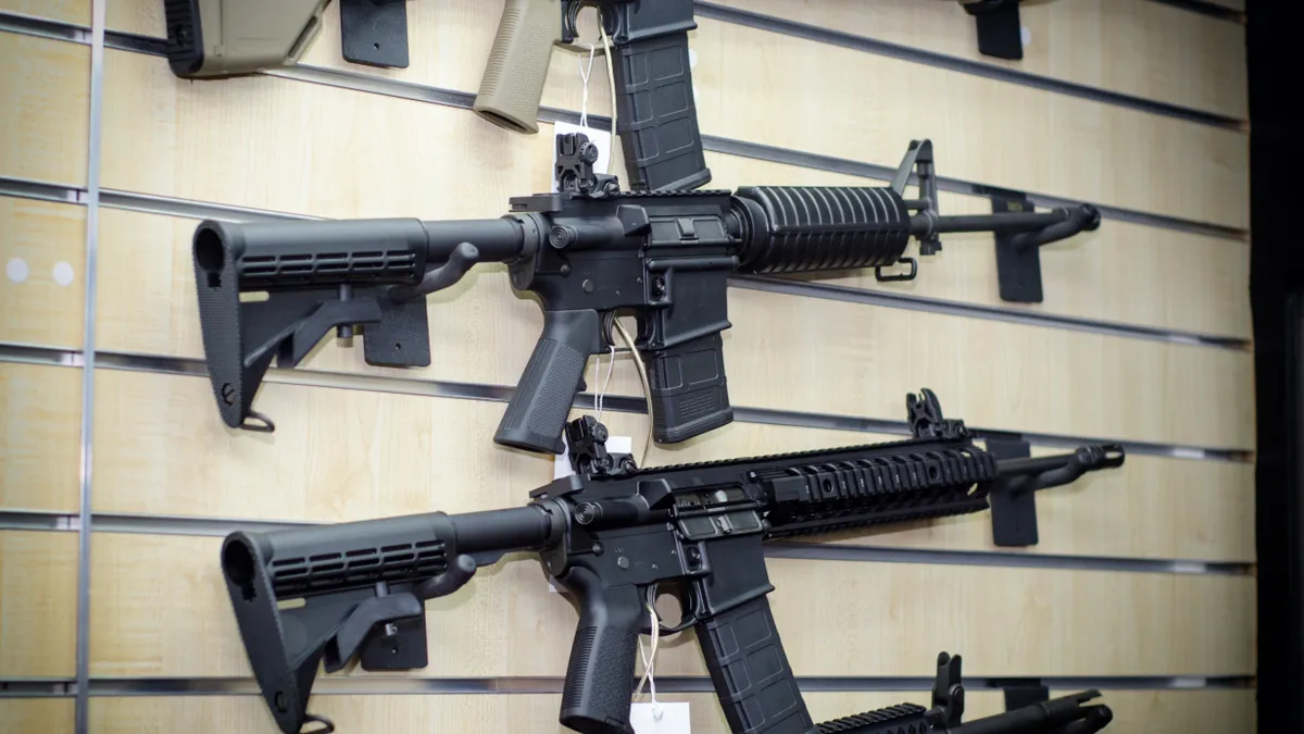 Semi-automatic rifles hanging on gun shop wall.