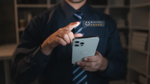 A person holds a smartphone with a product review icon on a website page.