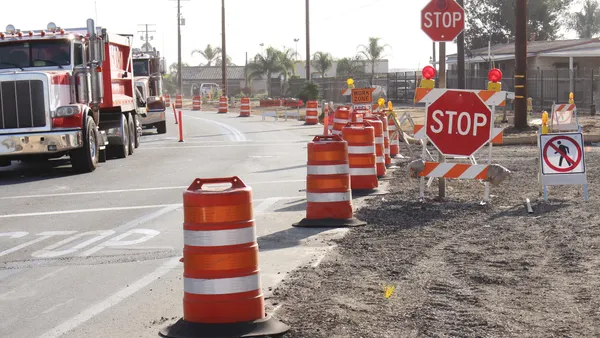 Trucks pull through a construction work zone.