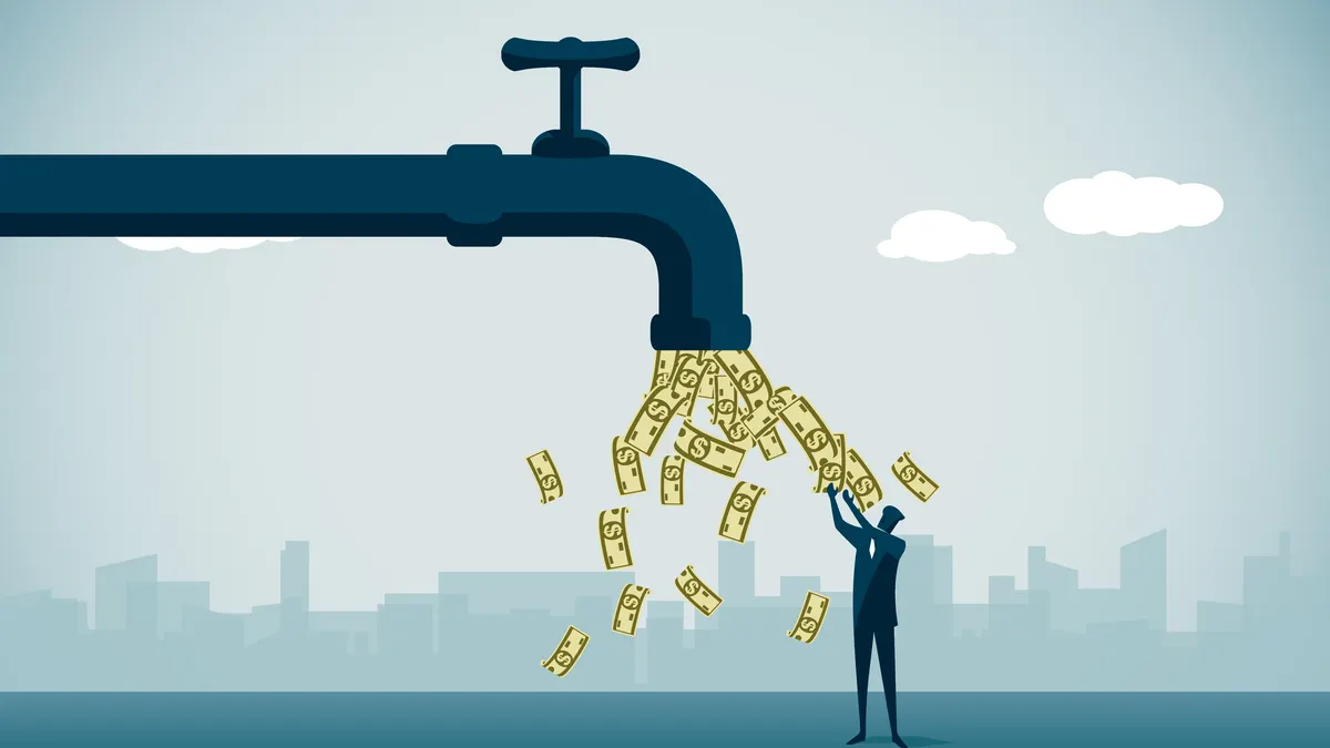 A business person stands under a faucet out of which dollars are flowing
