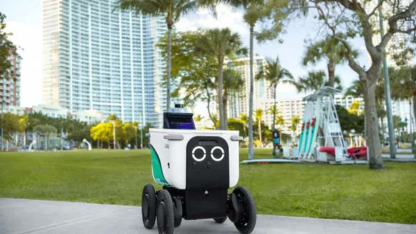 A Serve Robotics robot in front of some buildings in the Miami area.