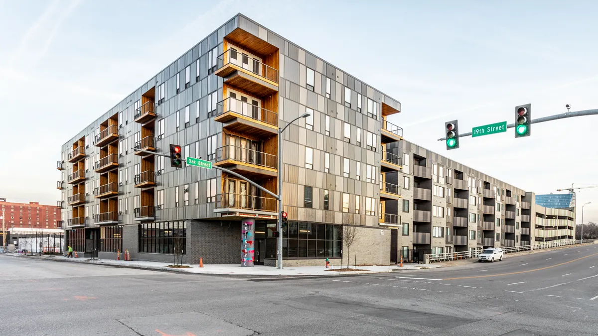 Four-level apartment building with a street in the foreground.