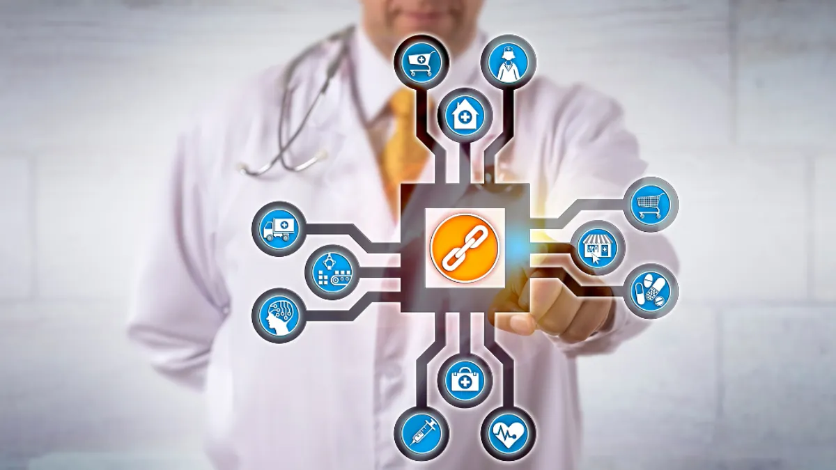 A person in a doctor's lab coat pointing to an illustration of a computer chip like chain.