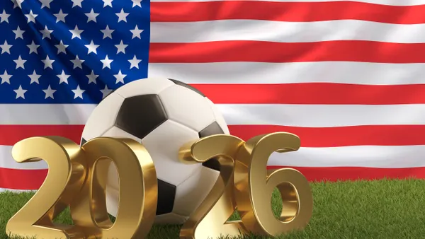 A soccer ball and bronze "2026" lettering in front of an American flag.