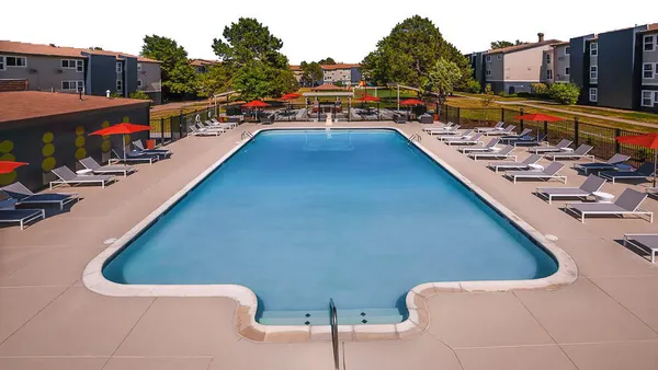 swimming pool surrounding by chairs and apartments