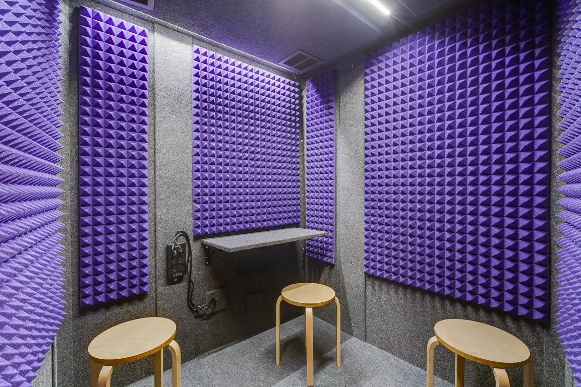 The interior of a sound recording booth with purple soundproofing foam.