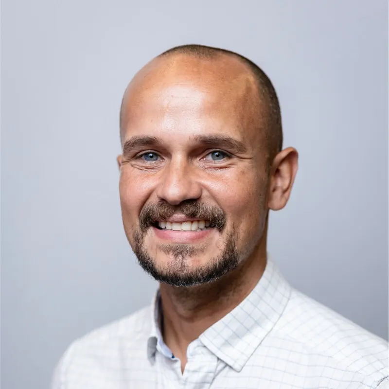 Headshot of a man with short trimmed hair.