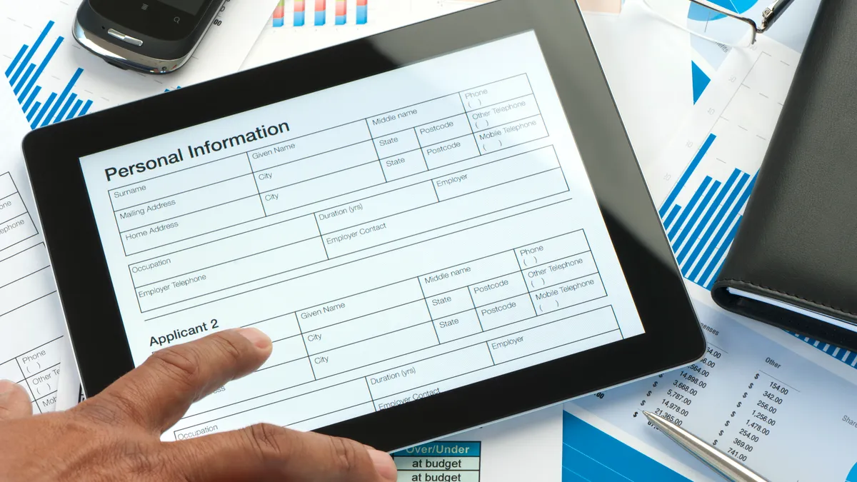 tablet showing online application form with paperwork