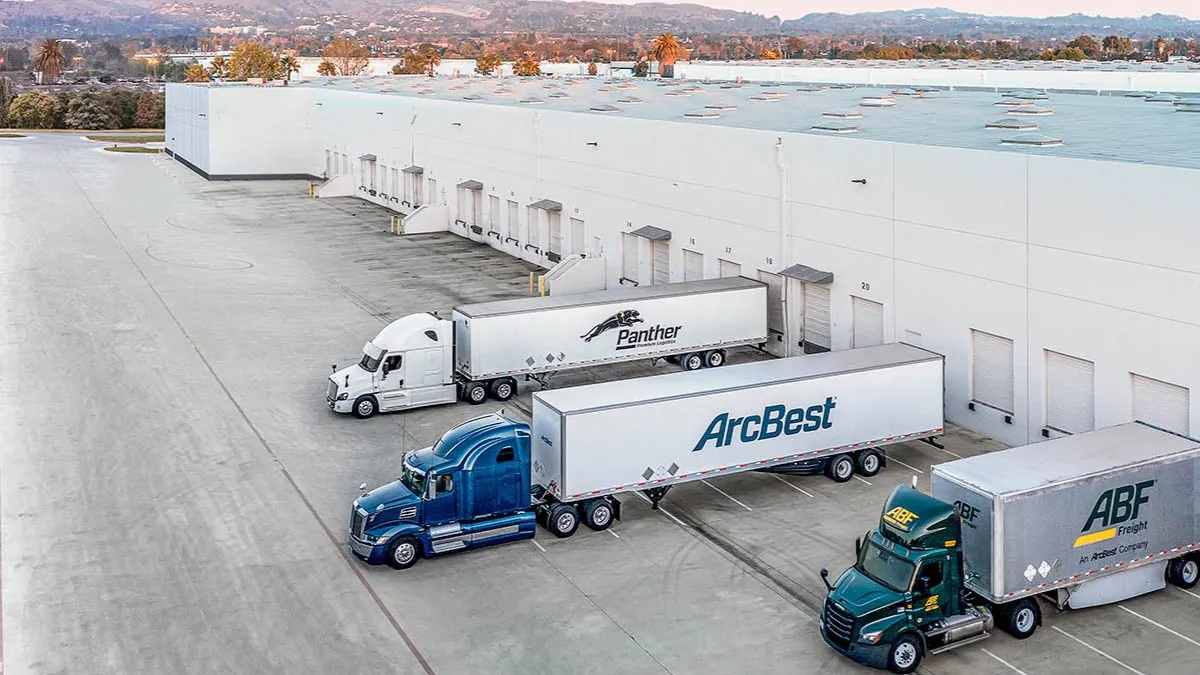 A warehouse showing three freight trucks parked and backed up on doors.