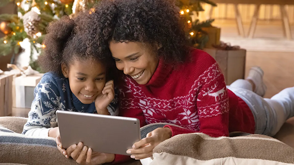 Smiling woman with children using tablet