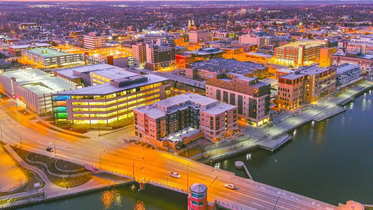 An aerial shot of Green Bay, Wisconsin at night shows buildings near the riverfront.