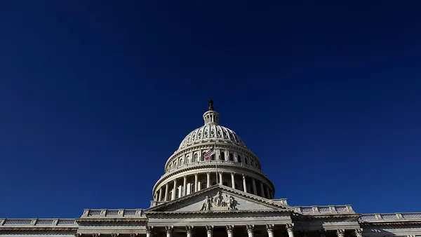 The U.S. capitol building stands in front of a blue sky.