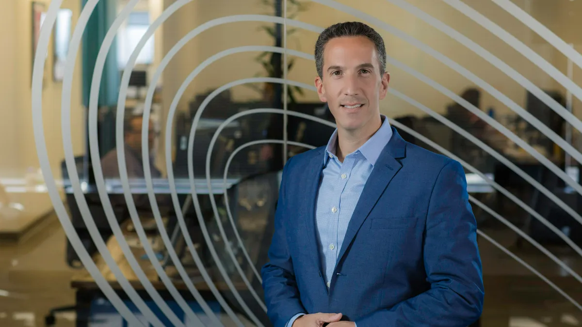 Phil Goldfeder stands in front of a glass wall.