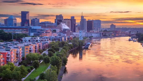 An aerial view of St. Paul, Minnesota depicts buildings and a bridge near a river.