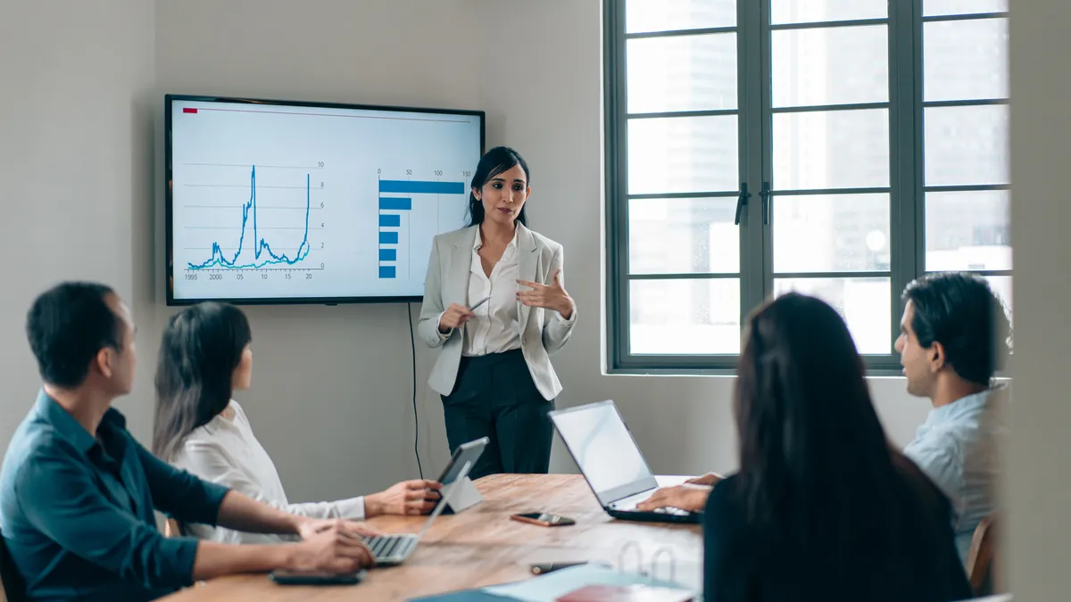 A team leader displays data on a screen during a group meeting