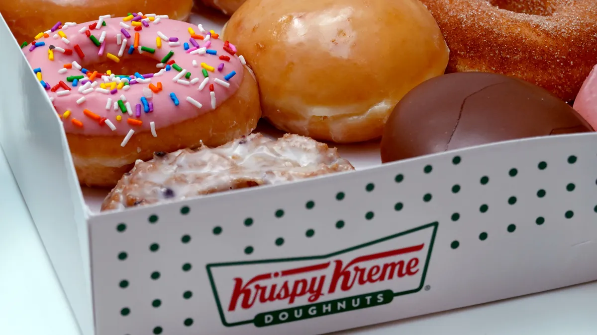 Image of assorted doughnuts in an open Krispy Kreme box.